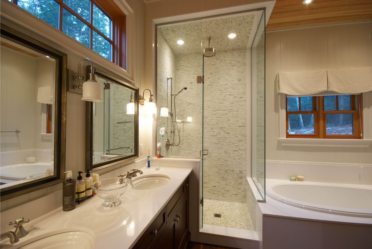 Custom Muskoka Cottage featuring a bathroom with two sinks , a tub , and a walk in shower.