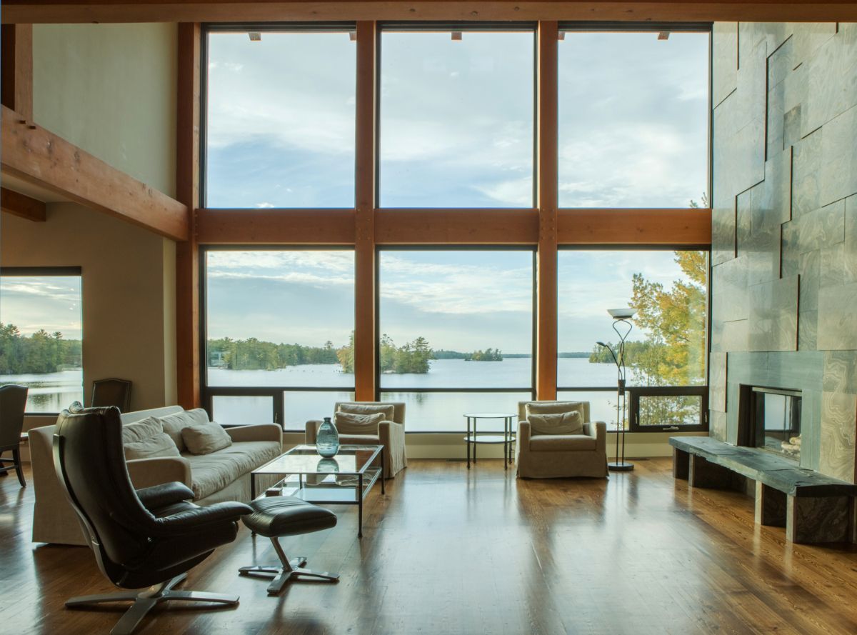 Custom Muskoka Cottage featuring a
living room with a lot of windows and a view of a lake
