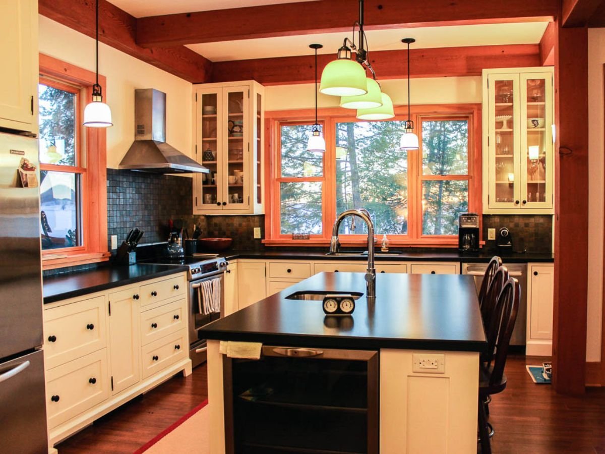 Custom Muskoka Cottage featuring a kitchen with white cabinets and stainless steel appliances