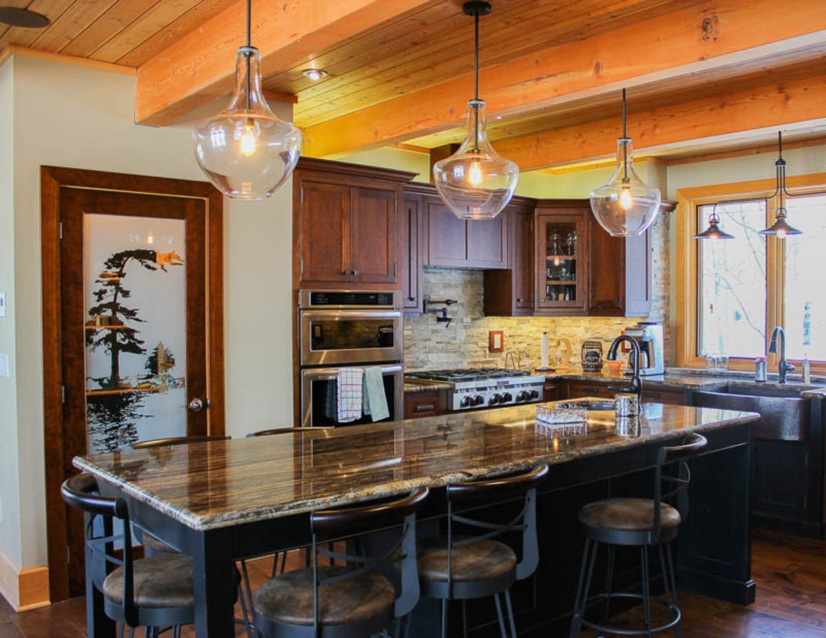 Custom Muskoka Cottage featuring a kitchen with a large island and stools