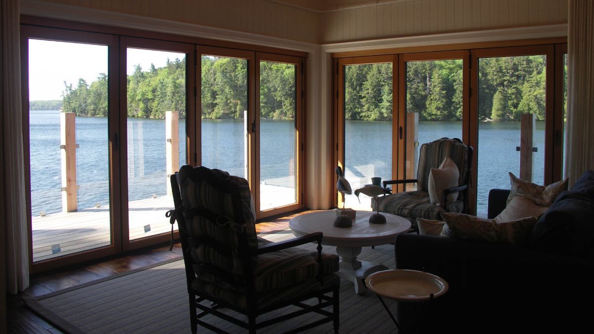 Custom Muskoka Cottage featuring a living room with a view of a lake