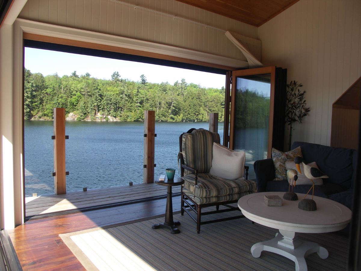 Custom Muskoka Cottage featuring a living room with a view of a lake