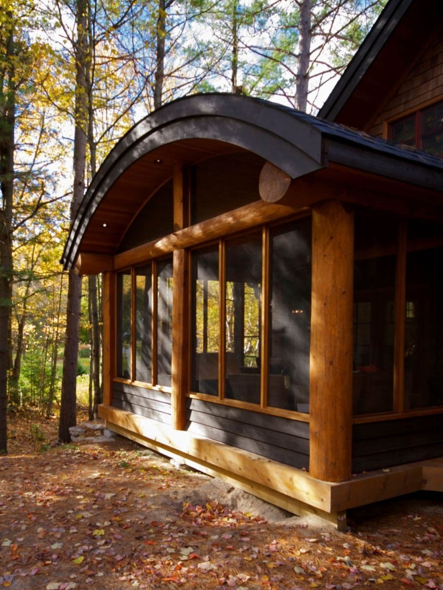 Custom Muskoka Cottage featuring a house with a screened in porch in the woods