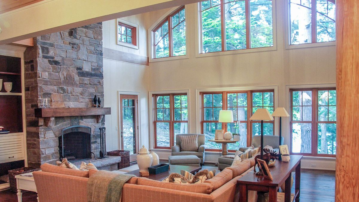 Custom Muskoka Cottage featuring a living room filled with furniture and a fireplace.