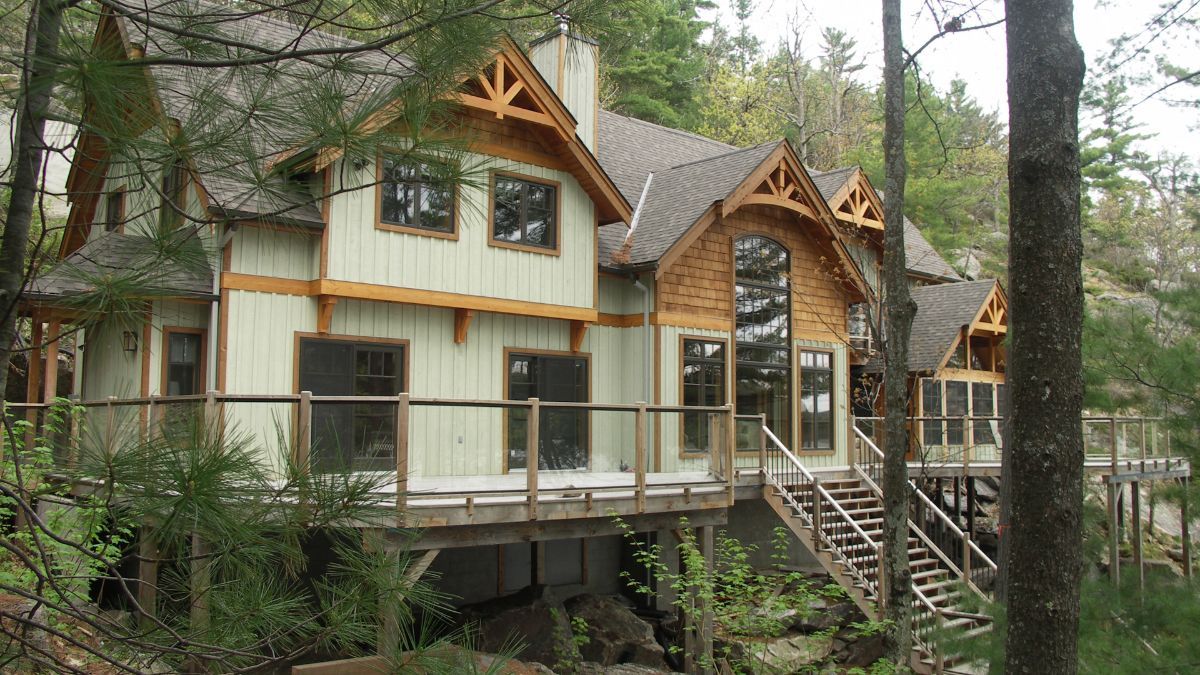 Custom Muskoka Cottage featuring a large house in the middle of a forest