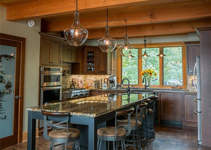 Custom Muskoka Cottage featuring a kitchen with a large island and stools and a large window.