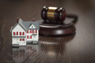 Gavel and miniature house figurine