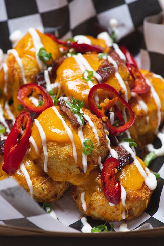 A close up of a plate of food on a checkered napkin on a table.