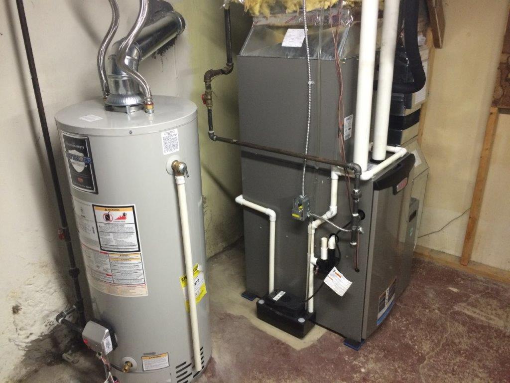 AC Unit — Kalamazoo, MI — Suburban Heating & Air Conditioning A water heater and furnace stand side-by-side in a basement.