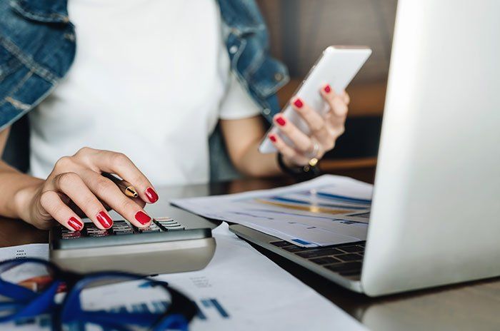 Woman Working With Calculator And Digital Tablet — Shelby, NC — Gale S. Elmore, CPA