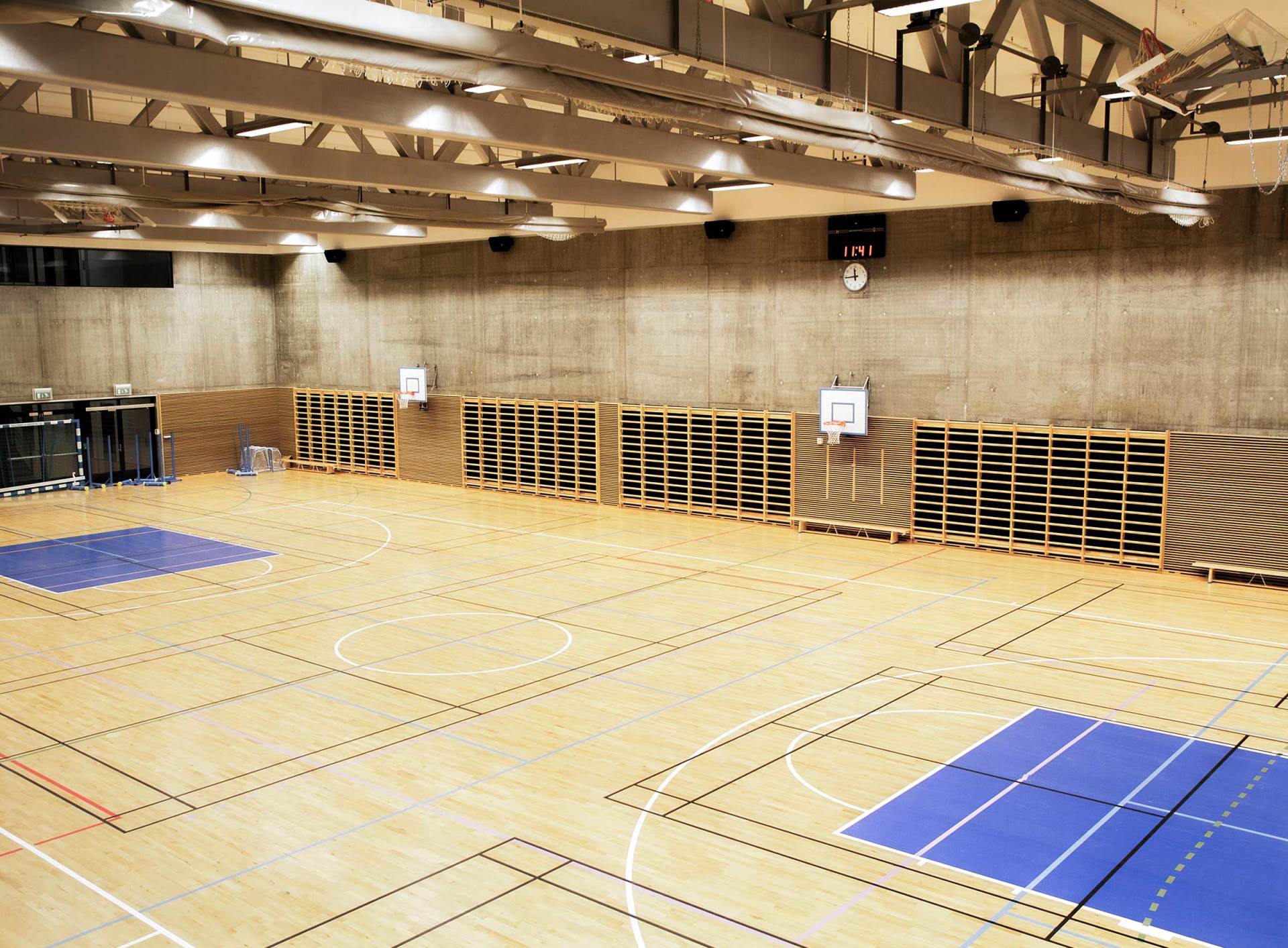 Et tomt treningsstudio med basketballbane og volleyballbane