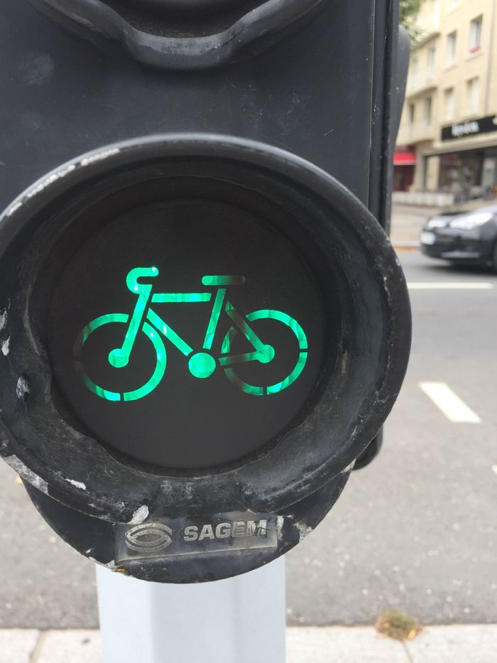 Groen fietssignaal brandt op een voetgangersverkeerslicht bij een oversteekplaats in de stad.