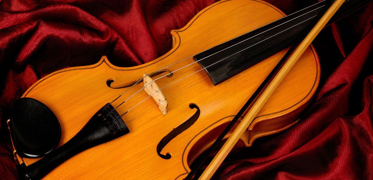 a brown colour violin kept on a red colour cloth