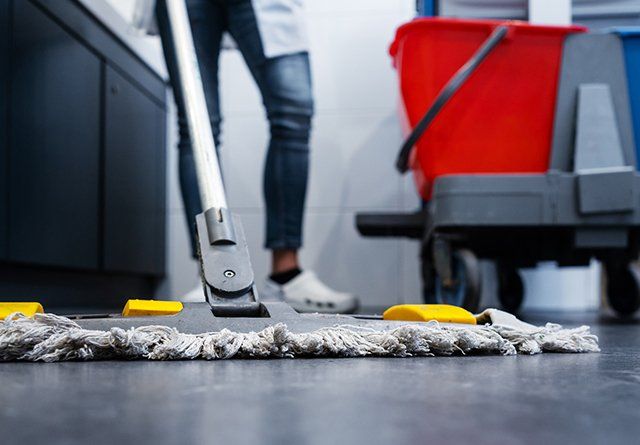Building Cleanup Service — Worker Cleaning the Floor in Prairieville, LA