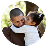 A man is holding a little girl in his arms.