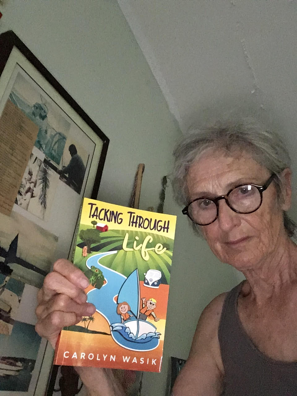author carolyn wasik holding a copy of her book tacking through life