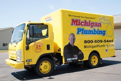 Yellow Michigan Plumbing truck with logo and phone number.