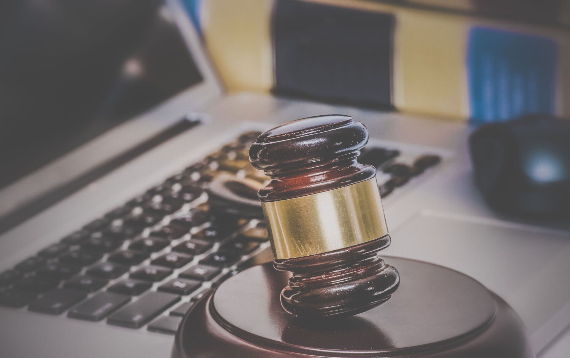 Judge’s gavel on a desk in front of a laptop keyboard