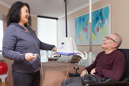 A woman is standing next to a man in a wheelchair.