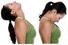 A woman in a green tank top is stretching her neck.