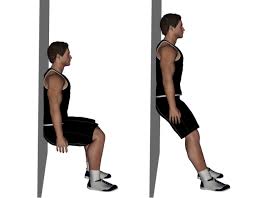 A man is sitting on a wall with his legs crossed.