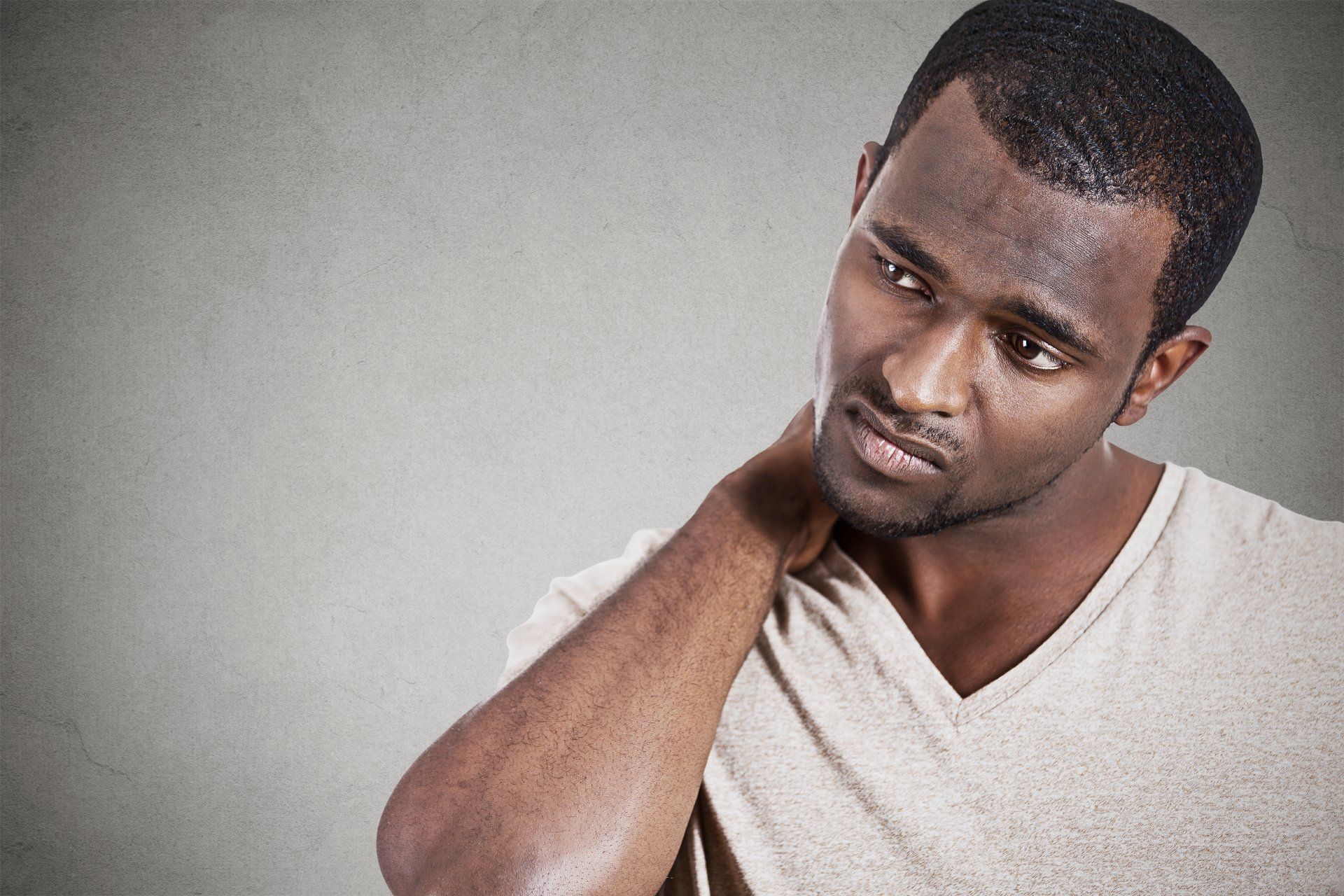 A man is holding his neck in pain.