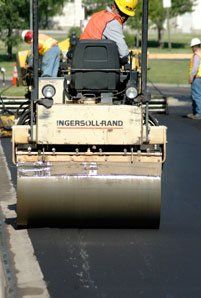 Asphalt construction services in progress in Denver, CO A contractor performing an asphalt overlay in Denver, CO