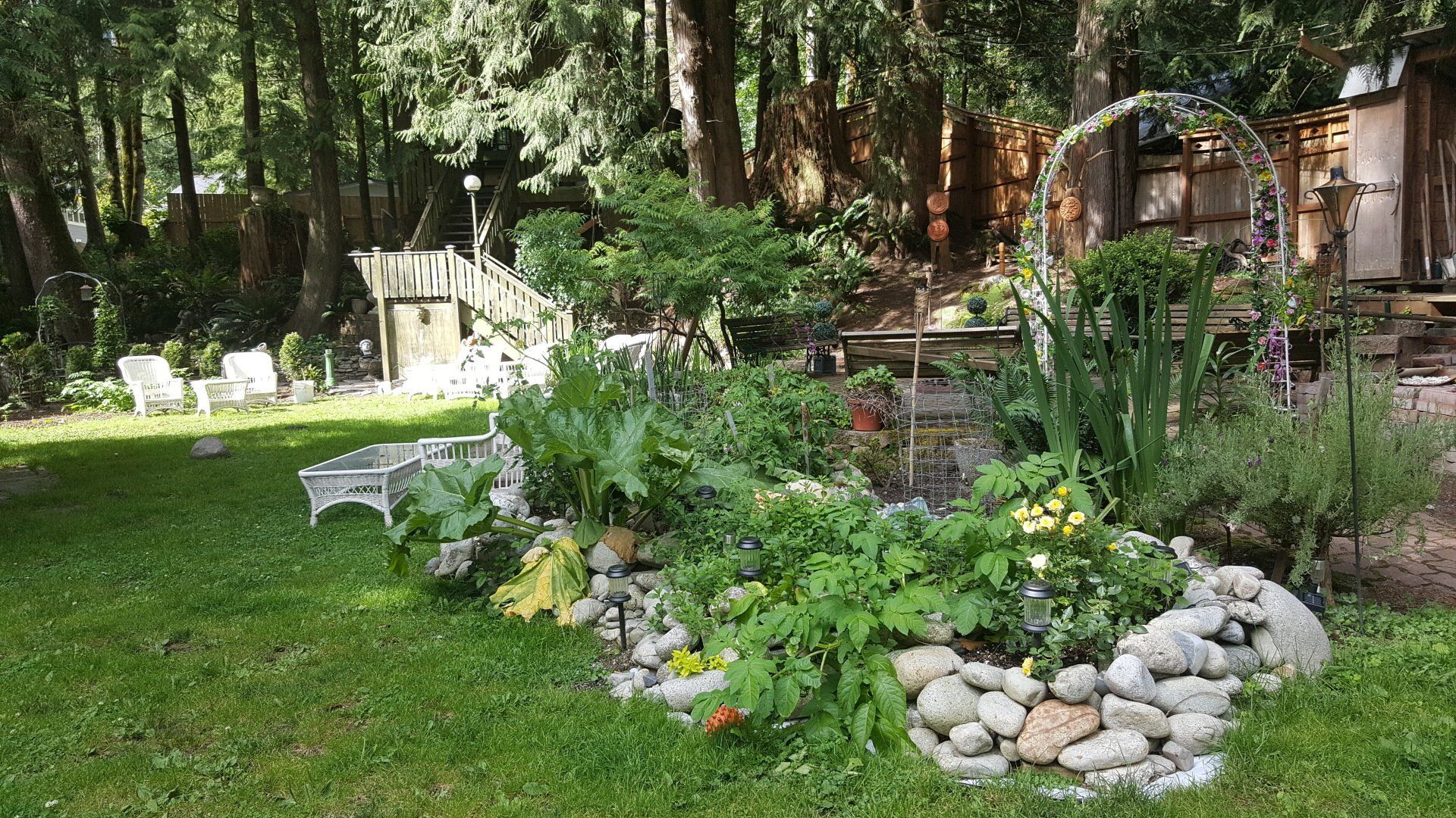 A garden or ritual area with a lot of plants and rocks in it.