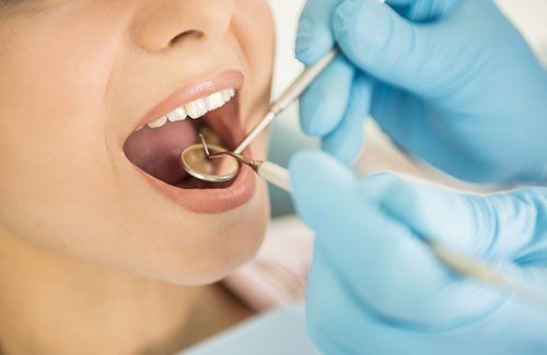 dentista analizza denti con specchietto