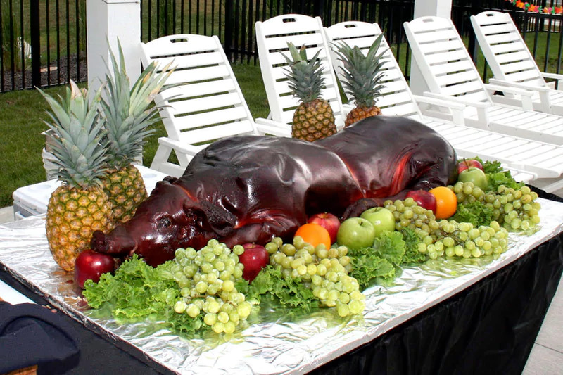 A pig covered in fruit and vegetables on a table