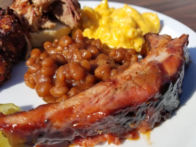 A white plate topped with meat beans and macaroni cheese