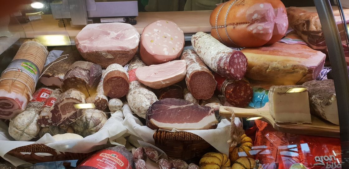 Di salumi appesi e sotto un'affettatrice