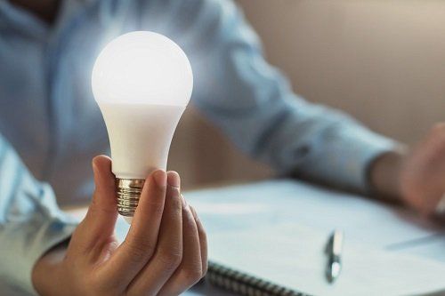 A person holding a LED light bulb