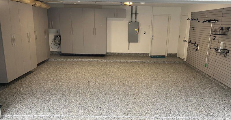 Two-car garage with gray cabinets, slatwall and a gray flake coated floor