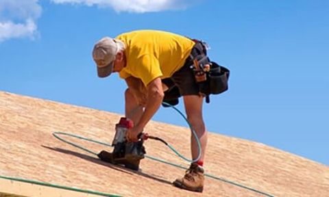 Roofer installs bitumen roof shingles — Roofing Services in Dr. Santa Maria, CA Roofer installs bitumen roof shingles — Roofing Services in Dr. Santa Maria, CA