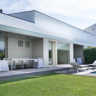 casa con tende bianche e giardino