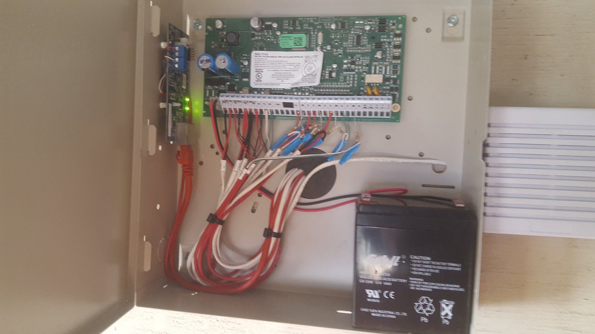 A box with a lot of wires and a battery inside of it.