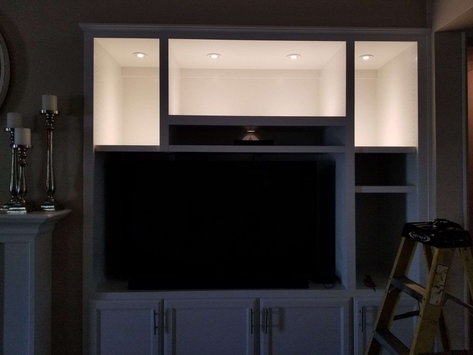 A ladder sits in front of a tv in a living room