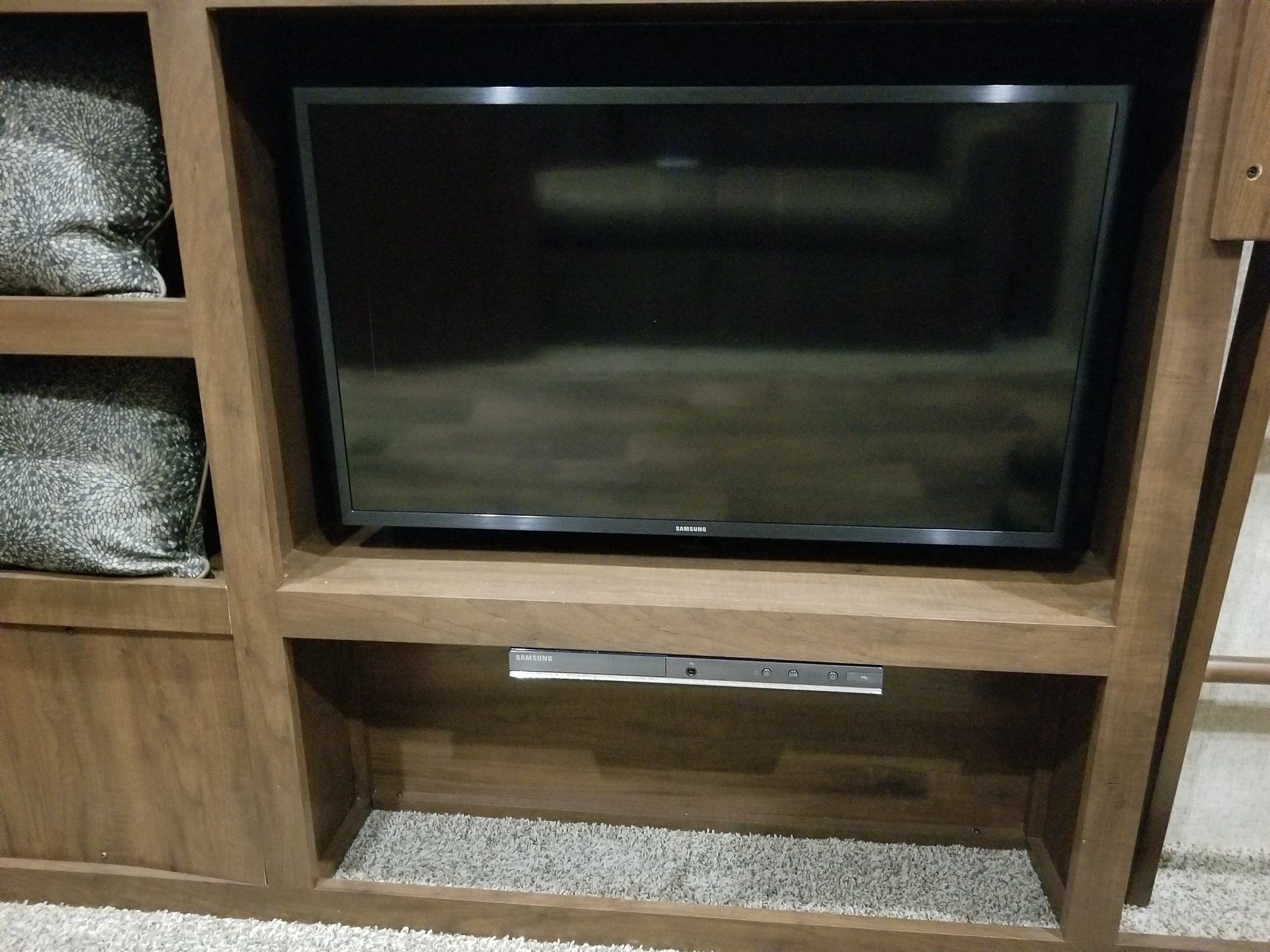A flat screen tv is sitting on top of a wooden entertainment center