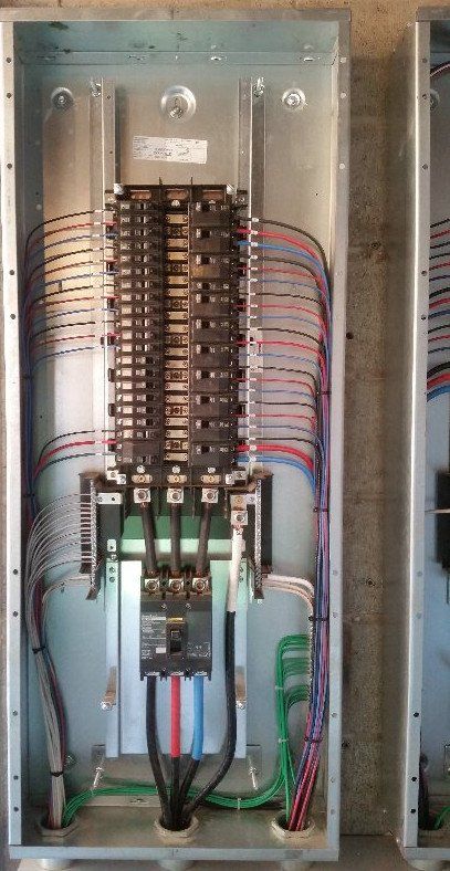 A electrical panel with a lot of wires coming out of it.