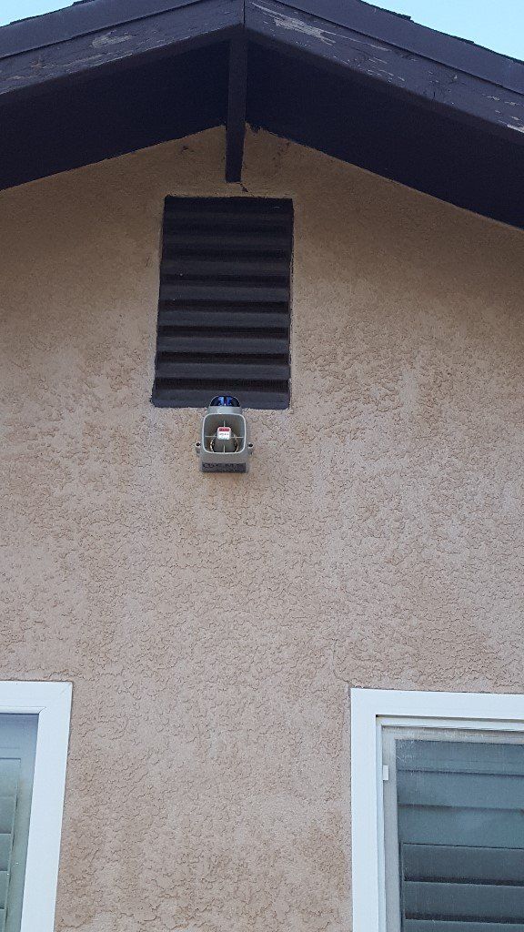 A lantern is hanging from the roof of a house.