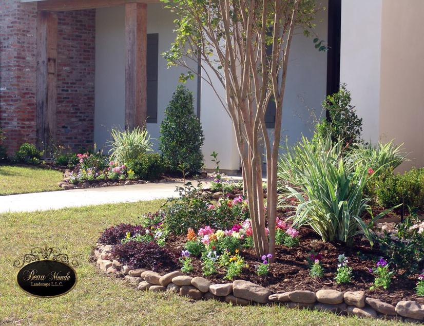 Landscaped garden bed with a variety of colorful flowers and plants. Installed by Beau Monde Lafayette, LA