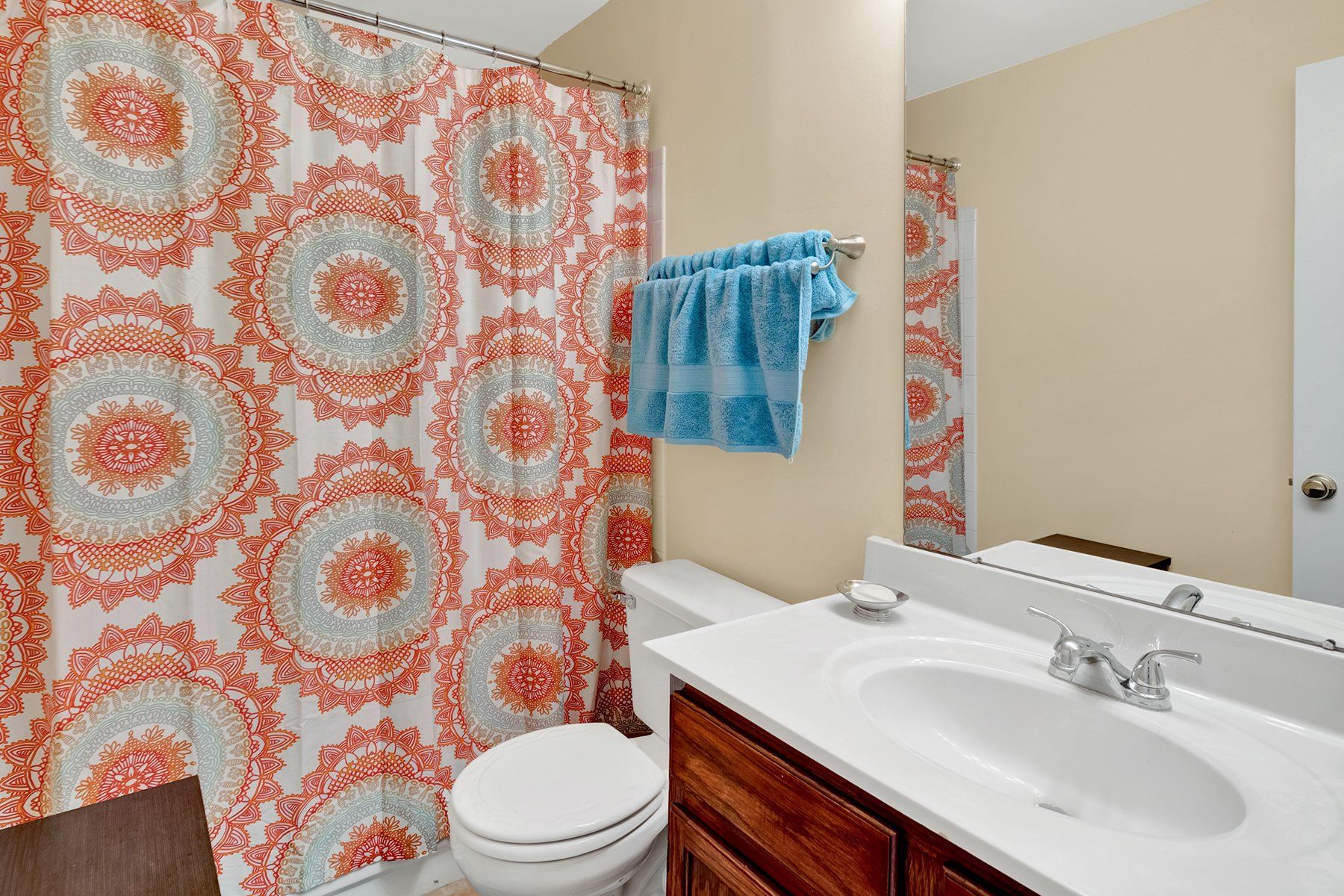 A bathroom with a toilet , sink , and shower curtain.
