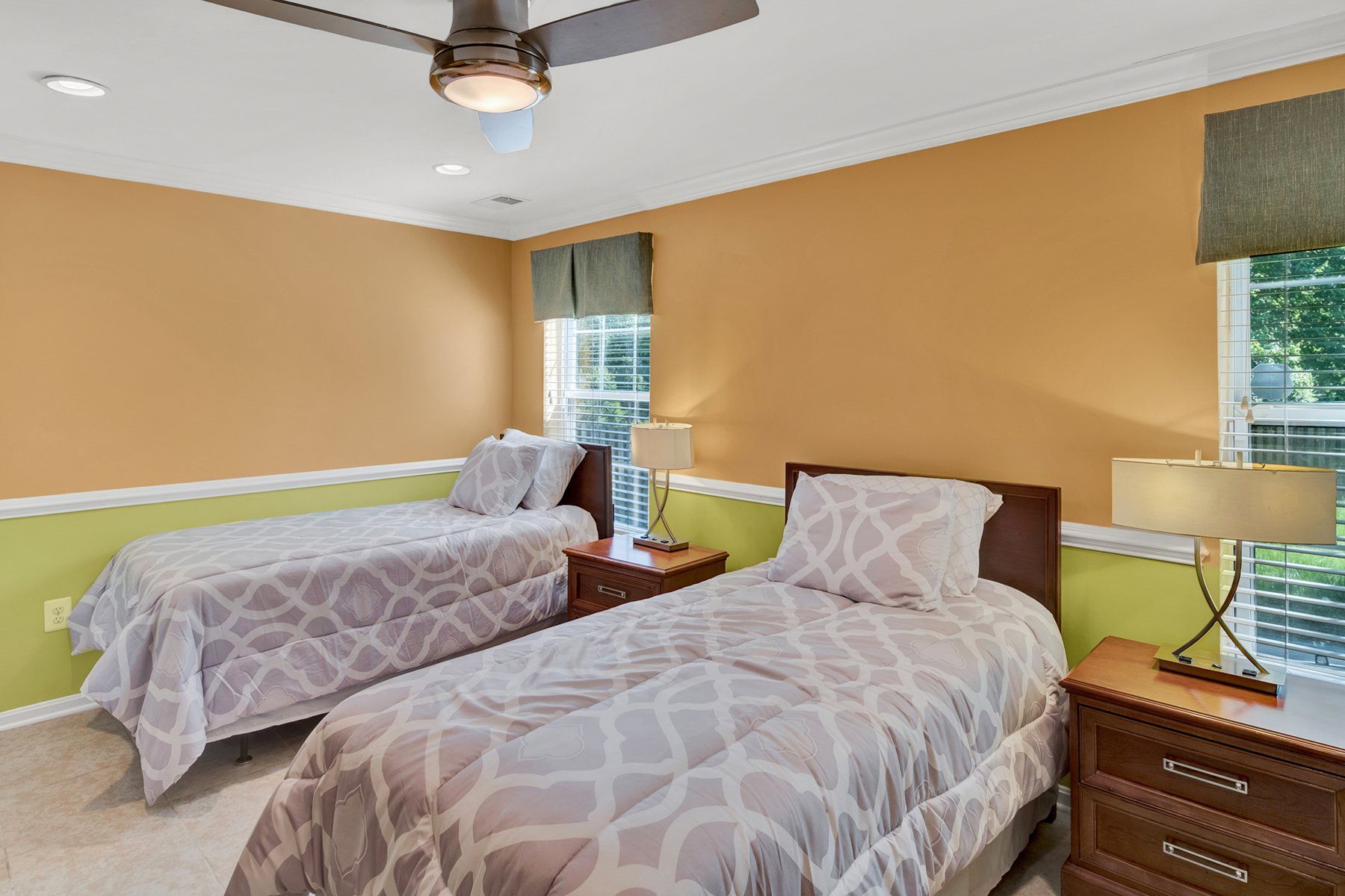 A bedroom with two twin beds and a ceiling fan.