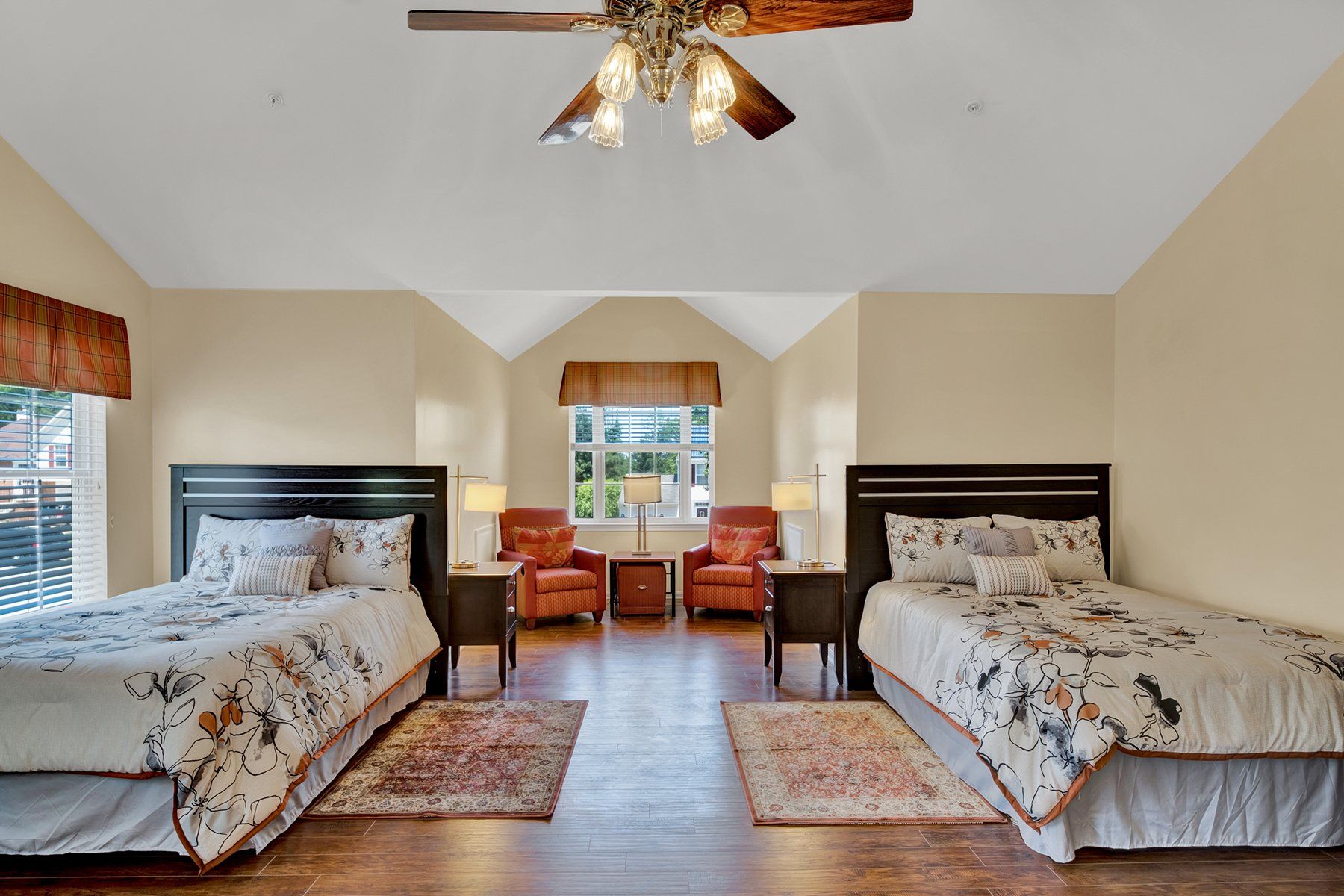 A bedroom with two beds and a ceiling fan.