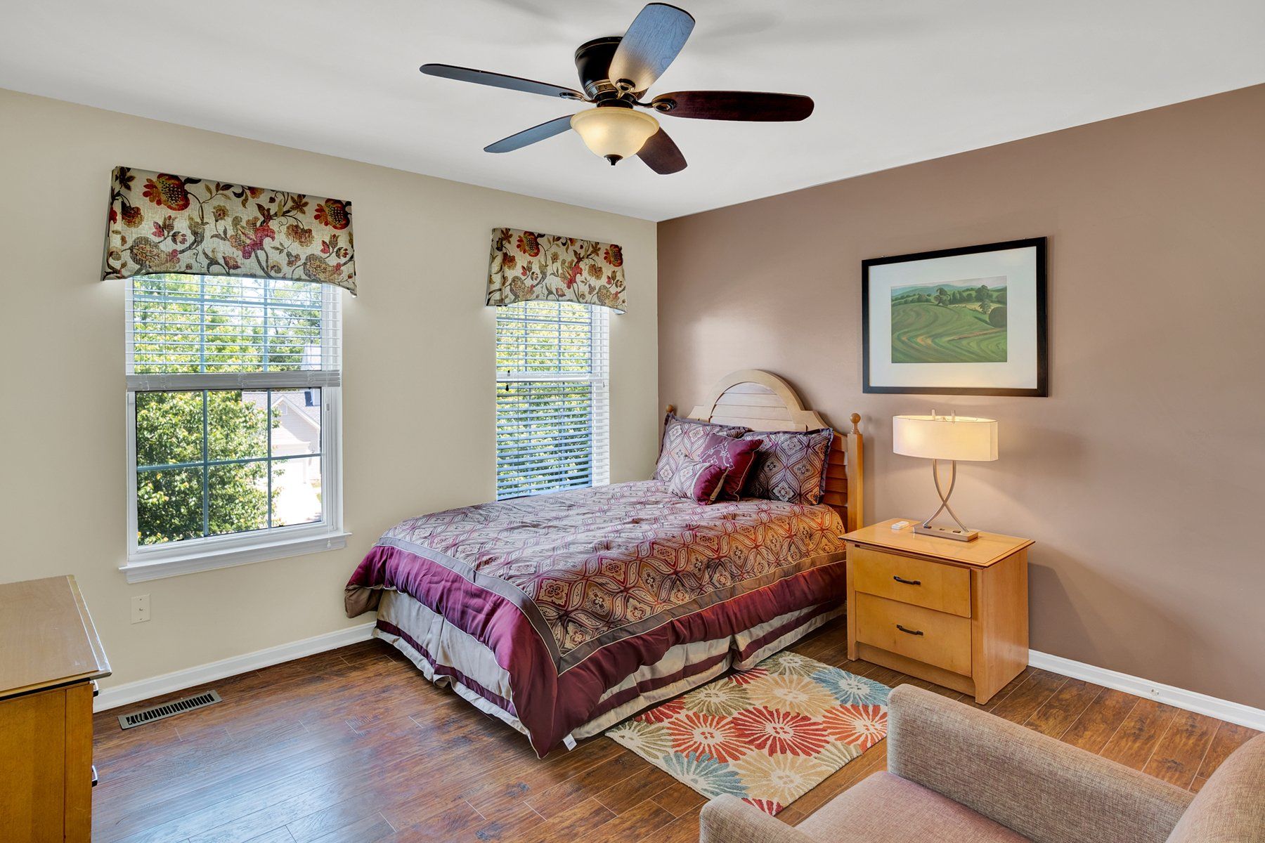 A bedroom with a bed and a ceiling fan