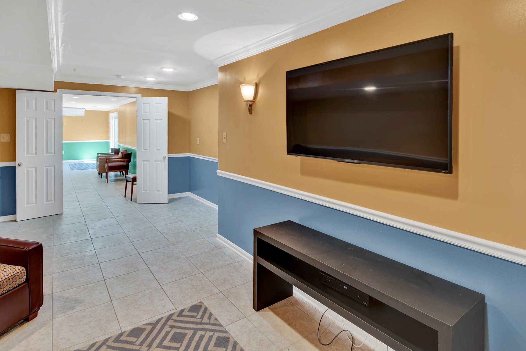 A living room with a flat screen tv on the wall.