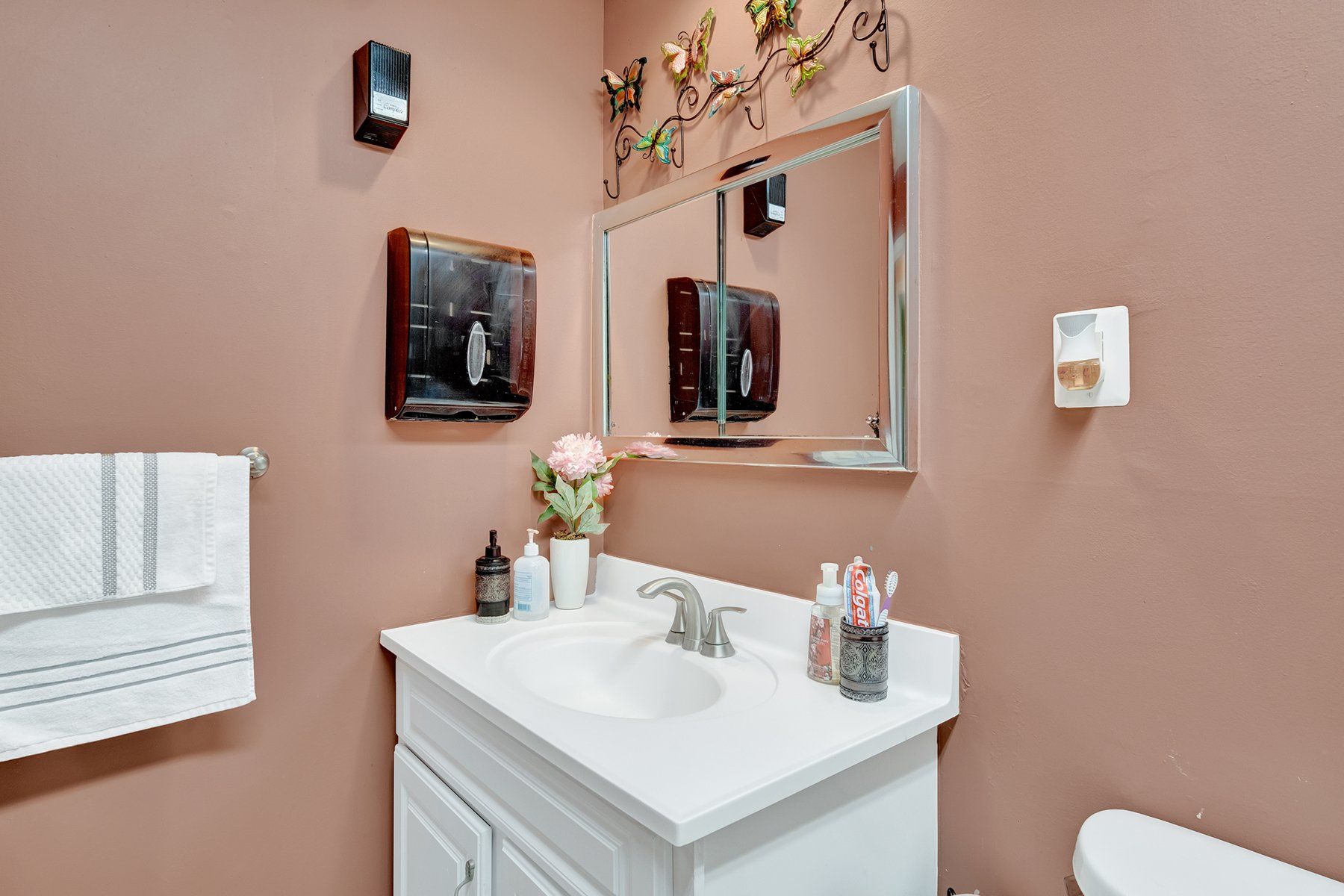 A bathroom with a sink , toilet and mirror.