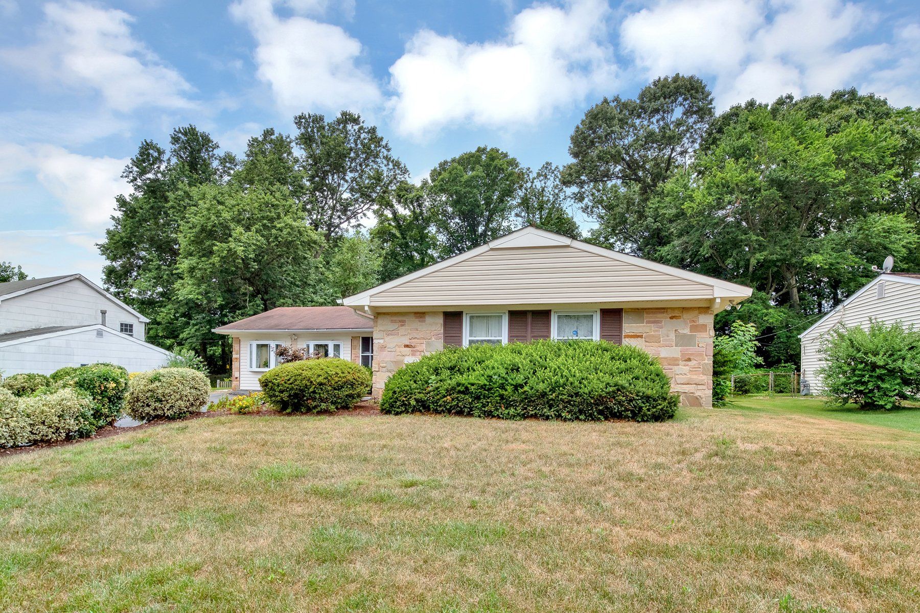 A small house with a large lawn in front of it