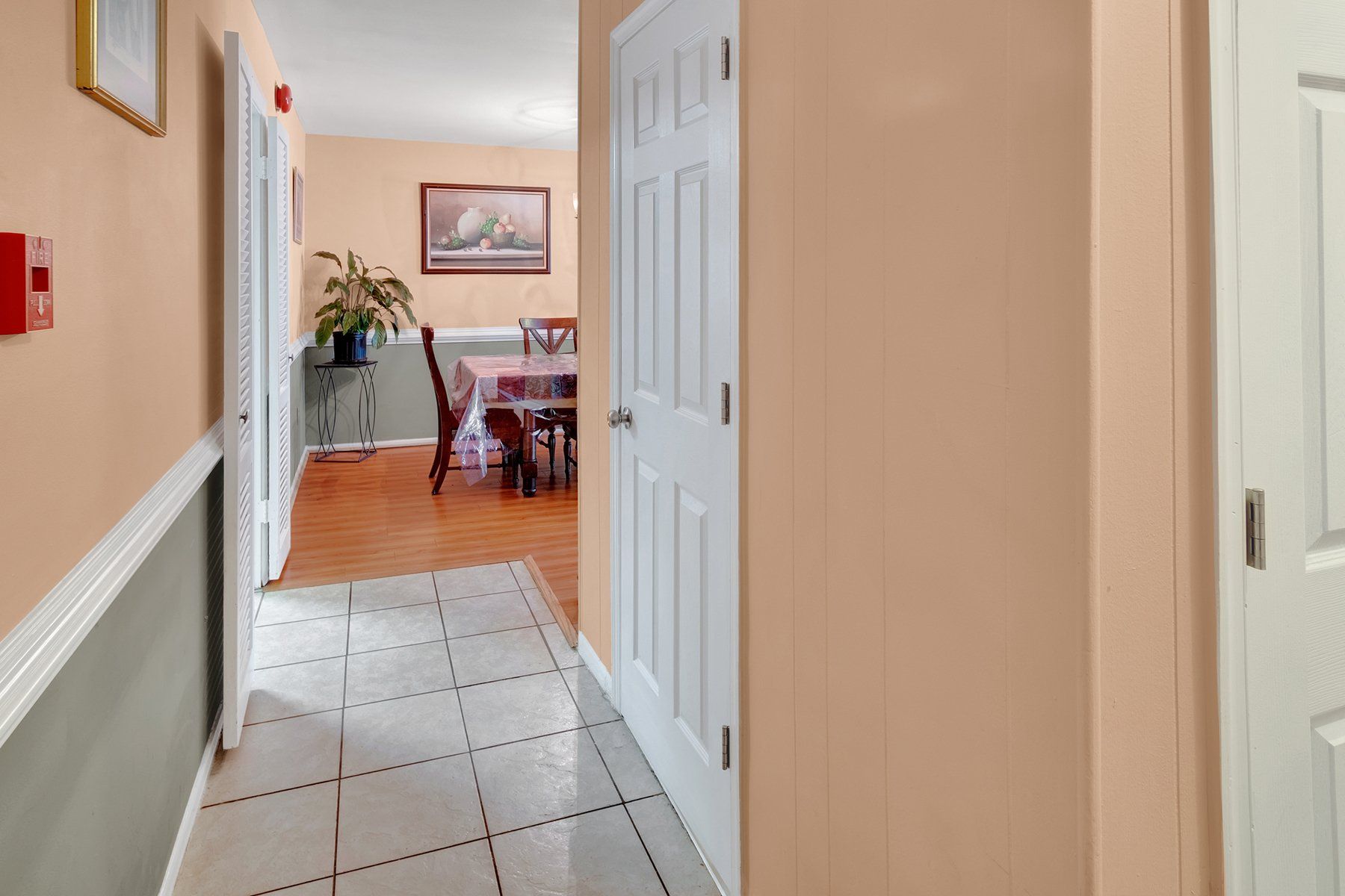 A hallway leading to a dining room with a table and chairs